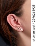 Small photo of piercings on an ear. Conch and helix piercings close up