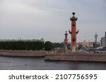 Small photo of SAINT PETERSBURG, RUSSIA 12.08.2021 Rostral Columns of granite and pudost stone with bronze anchors, ship prows decorations, god of sea and commerce statue (architect - Jean-Francois Thomas de Thomon)