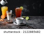 Latte, Americano, Orange juice, Lime tea served on dark background.