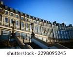 Small photo of A terrace of faded Victorian seafront houses, evening light, blue sky. Margate, Kent.