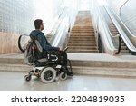 Small photo of Man with disability on wheelchair stopped in front of staircase, raising awareness of architectural barriers and accessibility issues