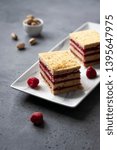 Small photo of Pistachio biscuit layered cake with fresh raspberry, square pieces, grey concrete background, nordic style