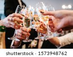 Cheers! People celebrate and raise glasses of wine for toast. Group of man and woman cheering with champagne.