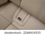 Small photo of Isofix for child car seats. Installing Isofix baby and child car seats for safety and to comply with the law. Interior of new clean expensive car. Seats with nappa beige leather. Details closeup.