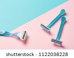 two disposable blue razors and one reusable on pink background. copy space, top view