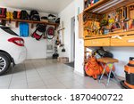 Home suburban car garage interior with wooden shelf, tools equipment stuff storage warehouse on white wall indoor. Vehicle parked at house parking background. DIY workbench for repair home appliances