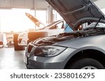 Car service center garage workshop. Vehicle raised on lift at maintenance station. Automobile repair and check up. Automotive insurance and technical checkup inspection diagnostic