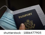 Blurred COVID-19 Vaccination Record card, Passport of USA and Medical Mask. Immune passport or certificate for travel concept. 