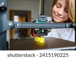 Small photo of A 10-year-old boy watches the 3D printing process with rapt attention