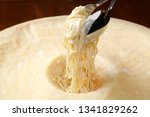 Small photo of Grana padano parmesan pasta cream cheese cooked inside a giant parmesan cheese wheel