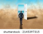A man in front of an open door in the desert. New beginning, new life, vacation, travel, vacation. Door in the desert, access to the beach, blue sea. Hope, dream, goal