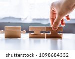 Small photo of The man points to the same two incompatible jigsaw puzzles. The concept of misunderstanding, non-conforming elements, mutually exclusive statements.