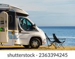 Small photo of Caravan with camp chairs on mediterranean coast, Spain. Wild camping on beach. Holidays and traveling in motorhome.
