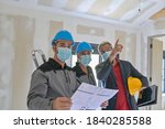 Small photo of Professional meeting on a construction site between the architect and the craftsmen who wear a protective mask against covid-19