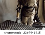Small photo of sandblasting a metal surface in a workshop close-up. a master in special clothing holds a sandblasting hose in his hands. working with sandblasting