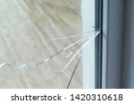 Crack on the glass at a residential house. Plastic window is damaged by cracks.