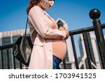 
pregnant woman in mask on the street