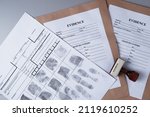 Small photo of Fingerprint card and paper envelopes for packaging evidence on a gray background, forensic fingerprinting