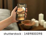 Woman hands using mobile phone takes photo at hotel room cozy bedroom blurred background