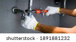 Small photo of Plumber's Hand Repairing Sink Pipe Leakage With Adjustable Wrench.
