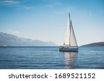 Sailing boat in the sea against the backdrop of mountains	