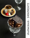 Small photo of Two kinds of madlen chocolate in a bowl with Traditional Turkish Coffee on black surface