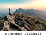businessman hike on the peak of rocks mountain at sunset, success,winner, leader concept