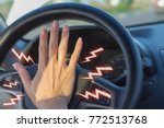 The girl's hand presses the horn in the car