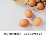 Small photo of Three eggs out of egg tray isolated on white background. Eggs protected in brown recycle paper tray at ease of use and handle. Top view image with copy space.