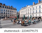 Small photo of Nantes, France - September 18, 2022: The place du Bouffay pedestrian square in the historic center with sidewalk cafes and the statue "Eloge du Pas de Cote" by french artist Philippe Ramette.