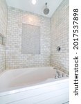 Small photo of Alcove bathtub with marble subway tile surround and shower head