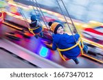 Child, cute boy riding chain swing carousel on sunset, motion blur, colorful background