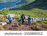 Happy family, standing on a rock and looking over Segla mountain on Senja island, North Norway. Amazing beautiful landscape and splendid nature in scandinavian country