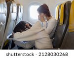 Small photo of Mother and child, boy and mom, sitting in airplane, having nausea, unease and discomfort from the turbulence