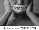 Small photo of Man with mouth sealed in adhesive tape with Freedom message. Free of speech, freedom of press, Human rights, Protest dictatorship, democracy, liberty, equality and fraternity concepts