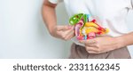 Small photo of Woman holding human Pancreatitis anatomy model with Pancreas, Gallbladder, Bile Duct, Duodenum, Small intestine. Pancreatic cancer, Acute and Chronic pancreatitis, Digestive system and Health concept