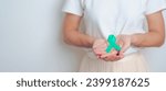 Small photo of woman holding Teal Ribbon for January Cervical Cancer Awareness month. Uterus and Ovaries, Cervix, Endometriosis, Hysterectomy, Uterine fibroids, Reproductive, Healthcare and World cancer day