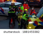 Small photo of Zutphen, The Netherlands - December 8, 2020: Early morning meeting of task force of ambulance personnel, police and fire fighters in face masks deliberating and organizing at an accident scene