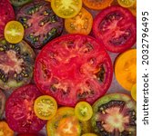 Small photo of Many organic tomato mix on table, flat lay. Fresh colorful tomatoes background, close up, top view. Best Heirloom Tomato Varieties. Delicious Heirloom tomatoes cut sliced in half.