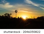 Rural sunrise with windmill and clouds