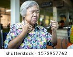 Small photo of Asian senior woman suffers from choke,clogged up food,elderly people choking during feeding,food might stuck in the throat and suffocate with sever pain injury,health problem, asphyxia,suffocation