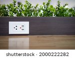 Electric power outlet socket with built in USB chargers on the table between seats for charging students' mobile phones or plugging in electrical appliances in restaurant or dining room at school