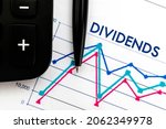 Notebook with Toolls and Notes about Dividends. . Business, tax and financial concept
