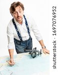 Small photo of Male yachtsman measures the distance with instruments on a sea chart. White background. Vertical.