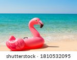 Pink inflatable mattress Flamingo on the beach close-up. The concept of tourism, travel, vacations