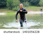 Small photo of Man in a wetsuit plodding on water of a lake, beach on a background. Demonstration for mass-media organized by Police Directorate. August 10,2018. Kiev, Ukraine