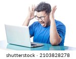 Small photo of young man screaming, shrieking, shouting in front of a laptop