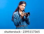 Smiling teenage girl clutching DSLR camera