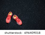 Top view of bright crimson sneakers for women, shoes for sports routine on a dark blurred background, copy space.