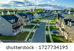Small photo of Aerial view of classic upper middle class neighborhood street with luxury single family homes with colorful siding for the up and coming with trees planted at equal distance in Maryland USA